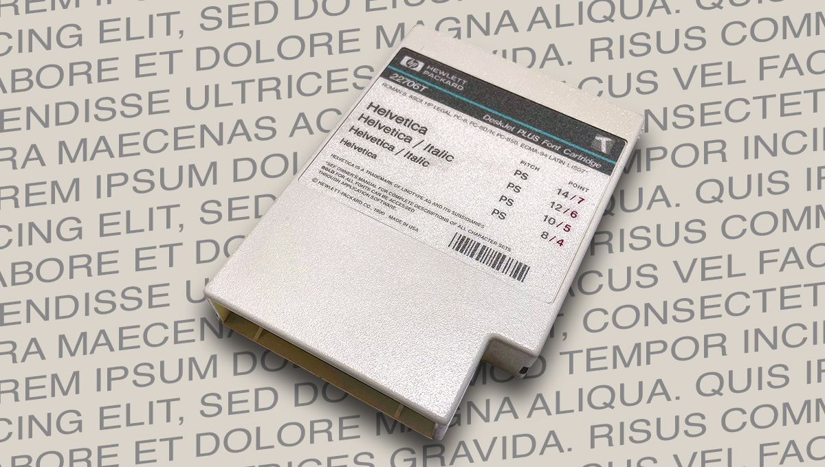 schrift-kassette-helvetica Das Bild zeigt eine alte Font Cartridge mit der Schriftart Helvetica auf einem Untergrund aus Buchstaben