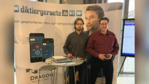 Das Bild zeigt unseren Messestand mit der Aufschrift "diktiergeraete.de" sowie die beiden Kollegen aus dem Team Sprachverarbeitung.